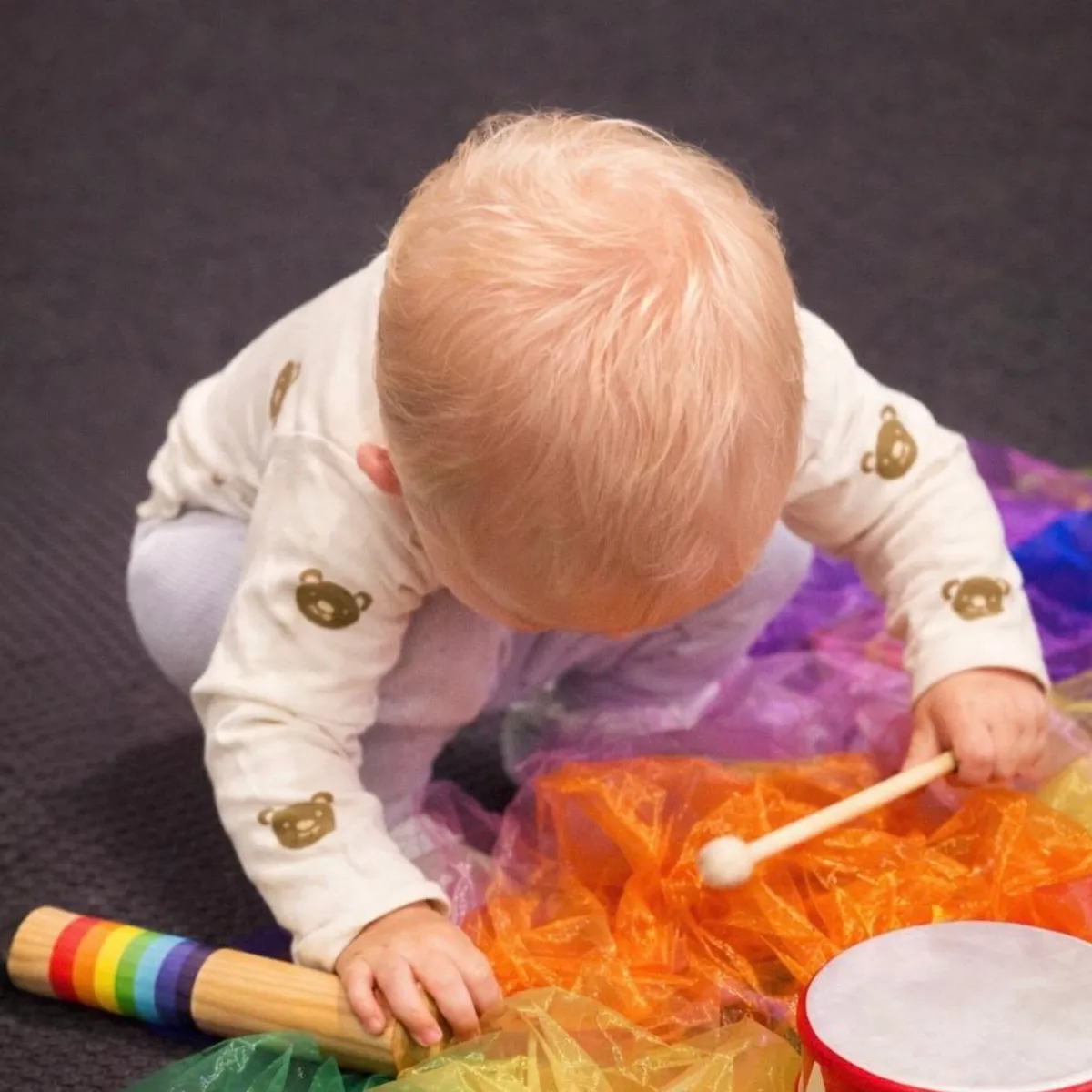 Baby exploring colourful instruments and scarves during Tell and Show class at Ranges Studio