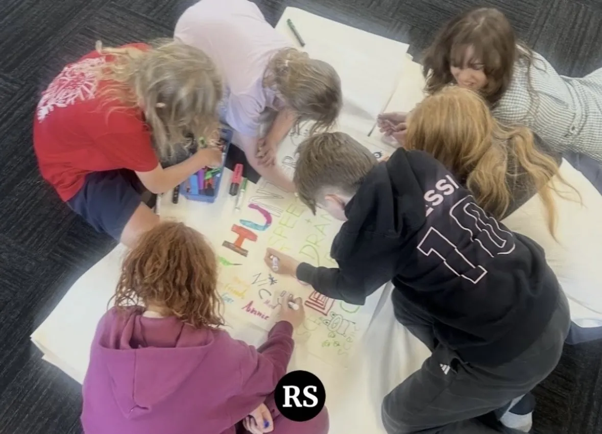 Students taking part in a group activity with their teacher at Ranges Studio