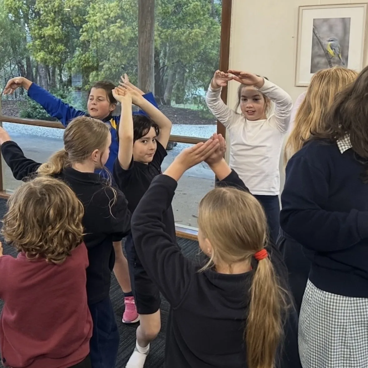 Group of speech and drama students with arms raised during a movement exercise