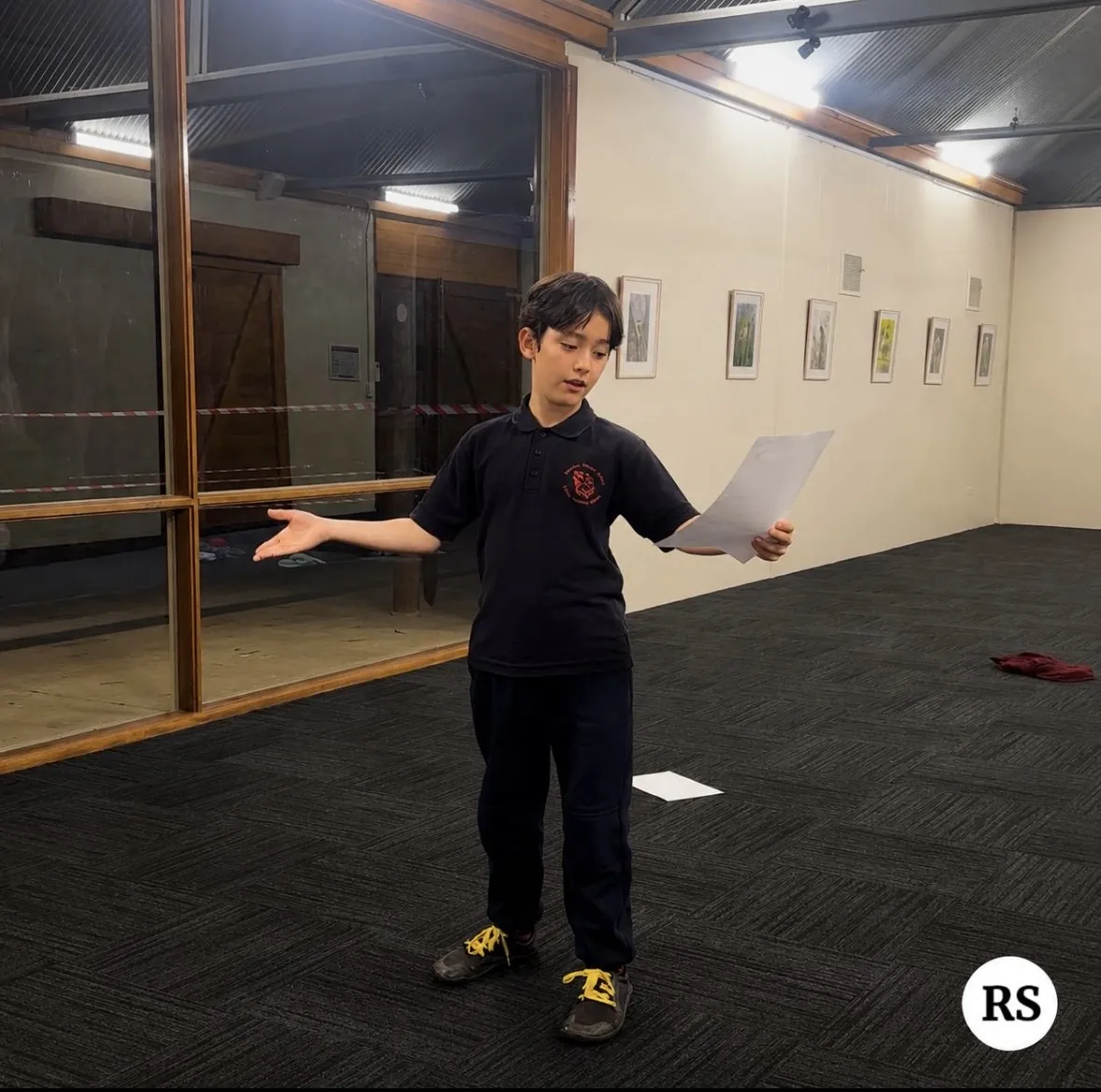 Young performer presenting expressively with a script during a speech and drama class at Ranges Studio