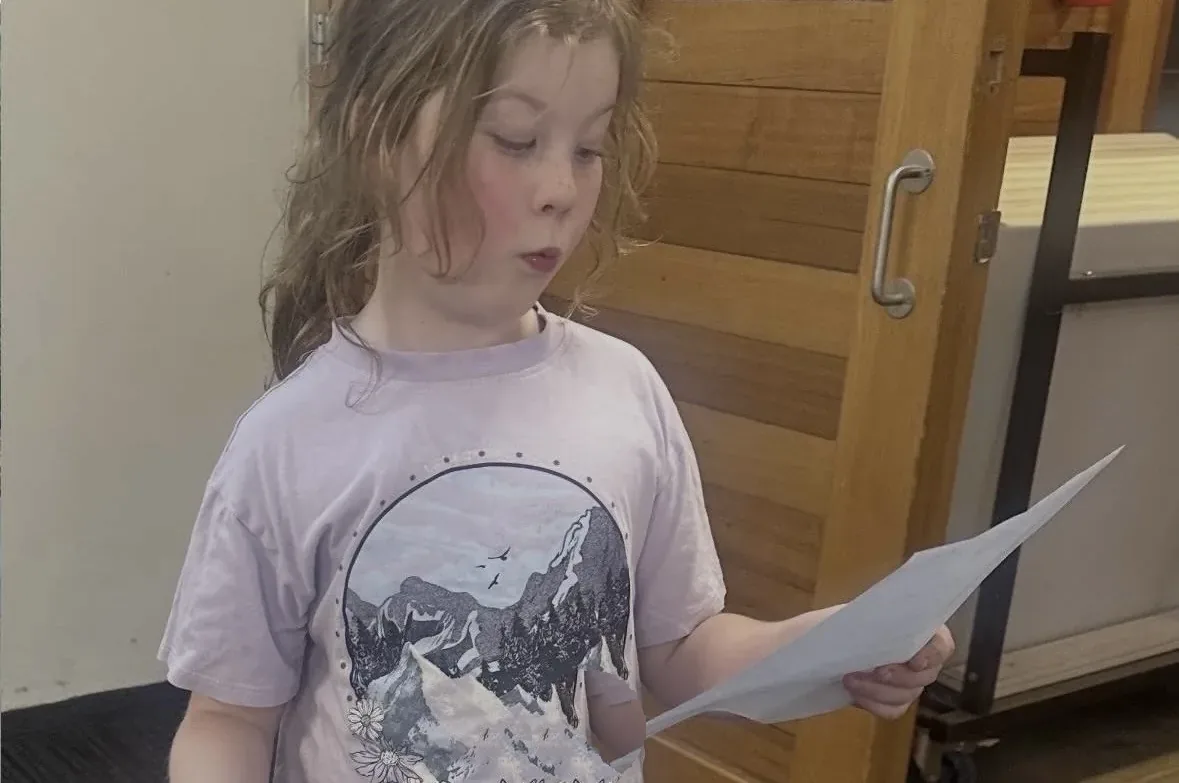 Student reading aloud from a script during a speech and drama class