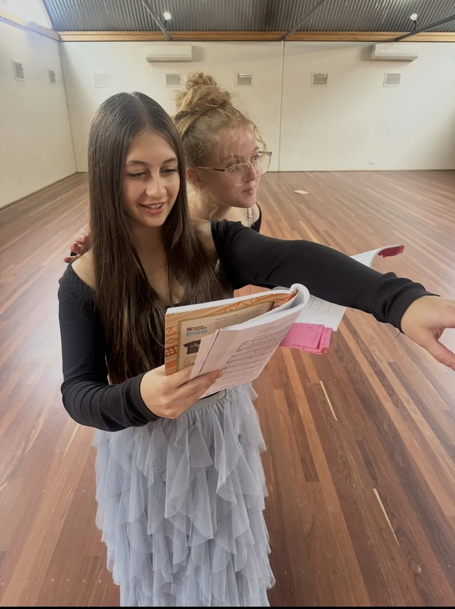 Two students sharing a script during a speech and drama class