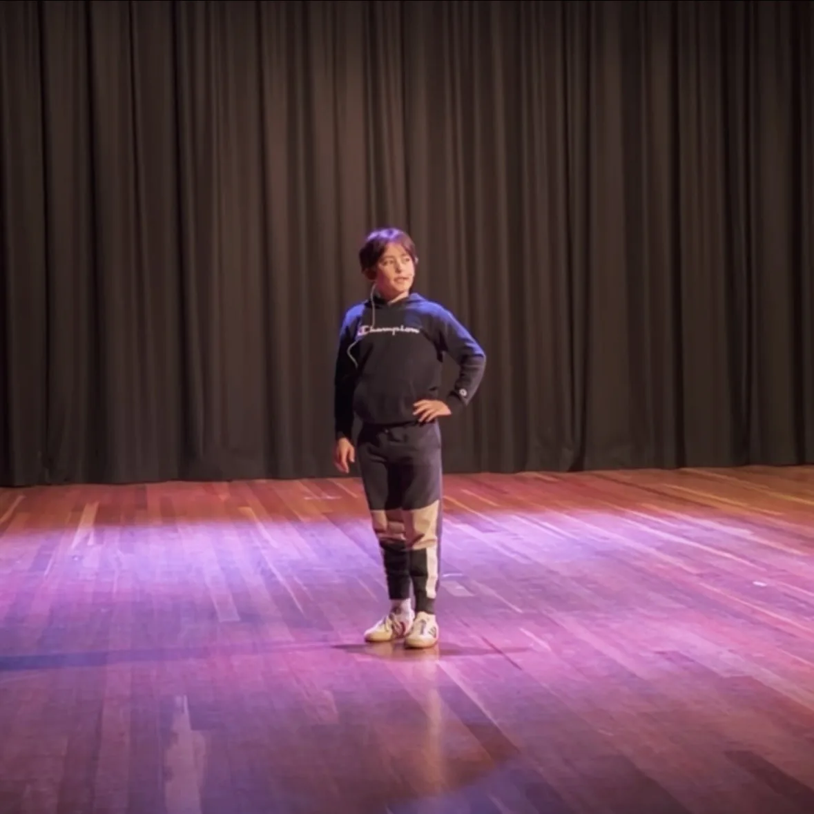 Young performer alone on a lit stage during a Ranges Studio showcase
