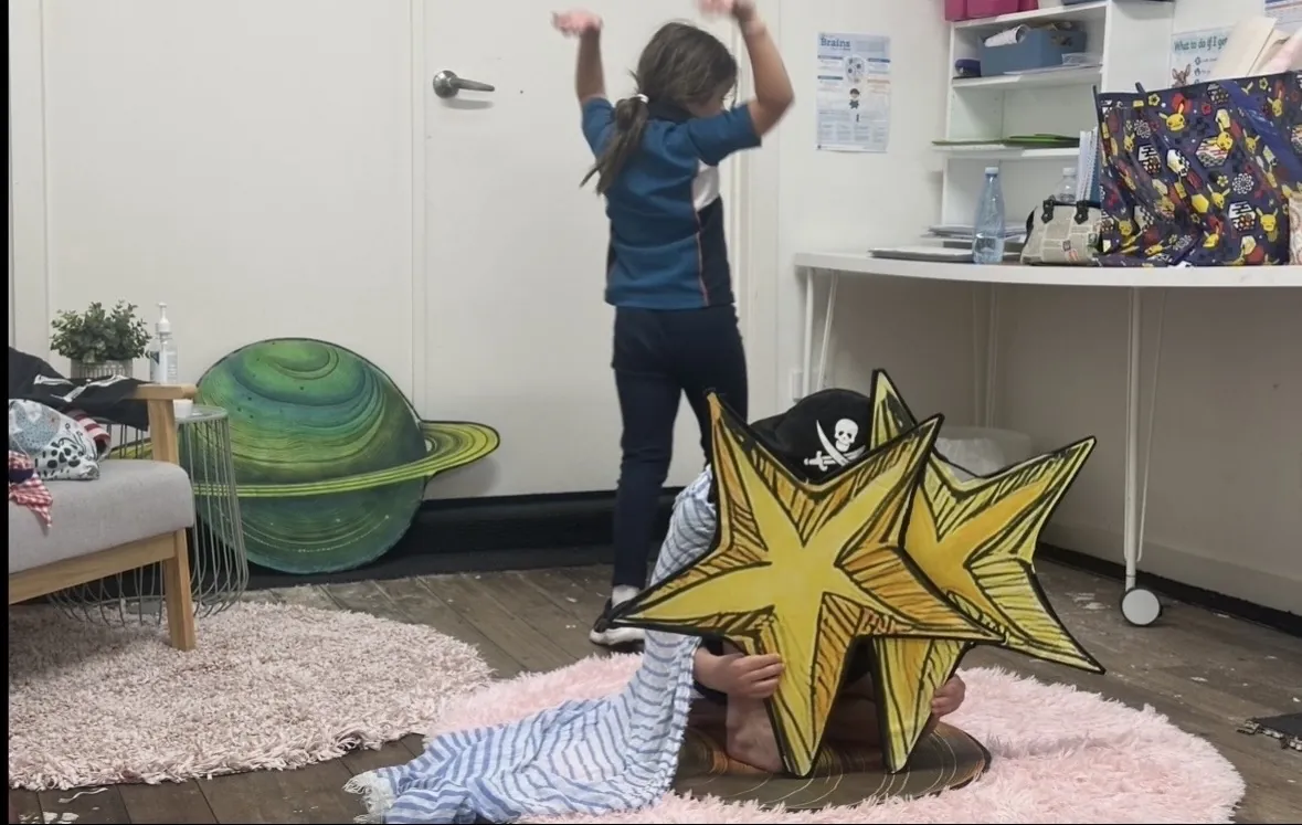 Student holding a glowing star prop during a speech and drama class