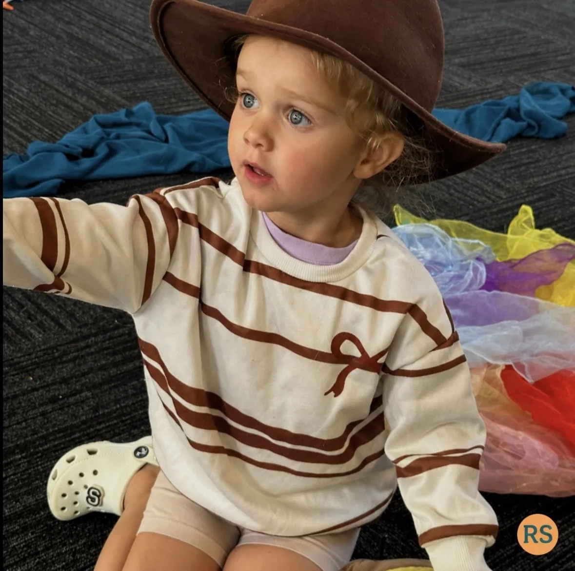 Young child wearing a cowboy hat during dress-up play at a Tell & Show class at Ranges Studio