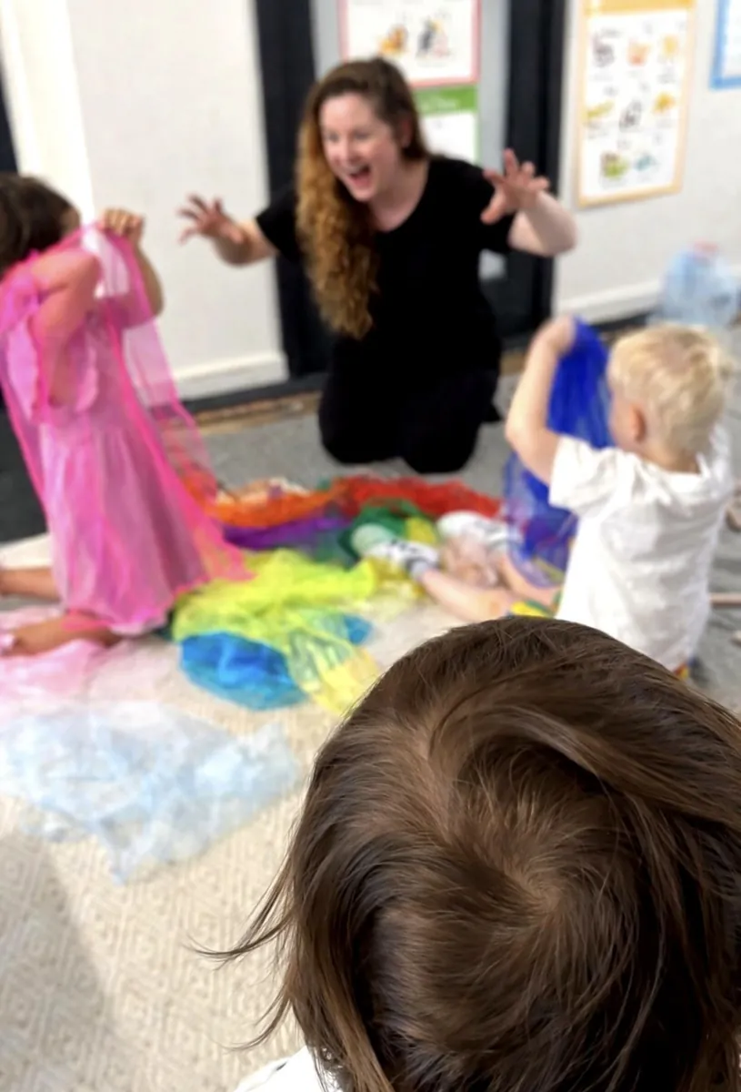 Young children in dress-up costumes during imaginative play at a Tell & Show class