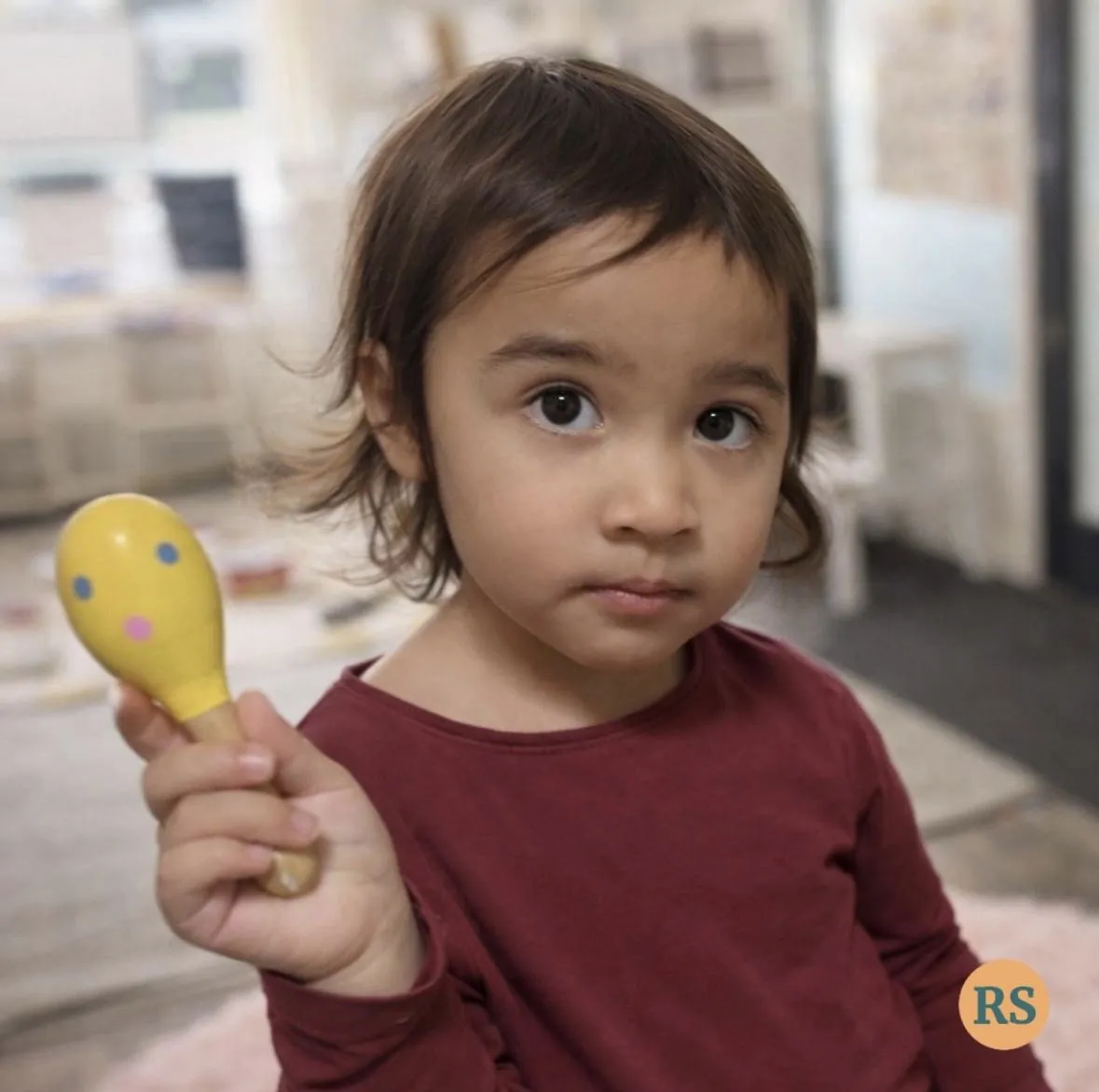 Young child exploring a natural leaf prop during a Tell & Show session