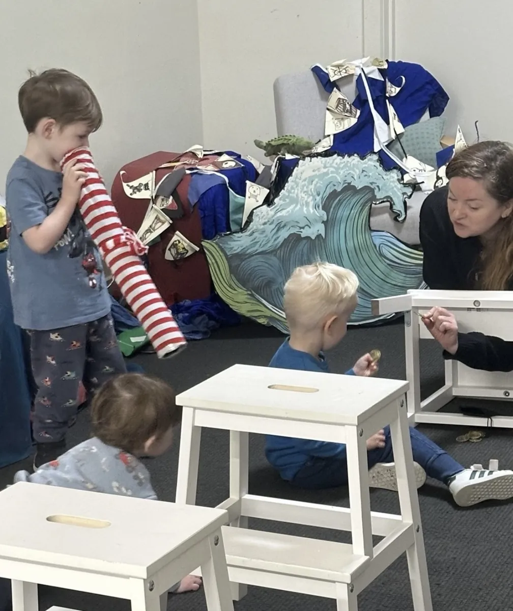 Young children with soft toys at the activity stools during a Tell & Show class
