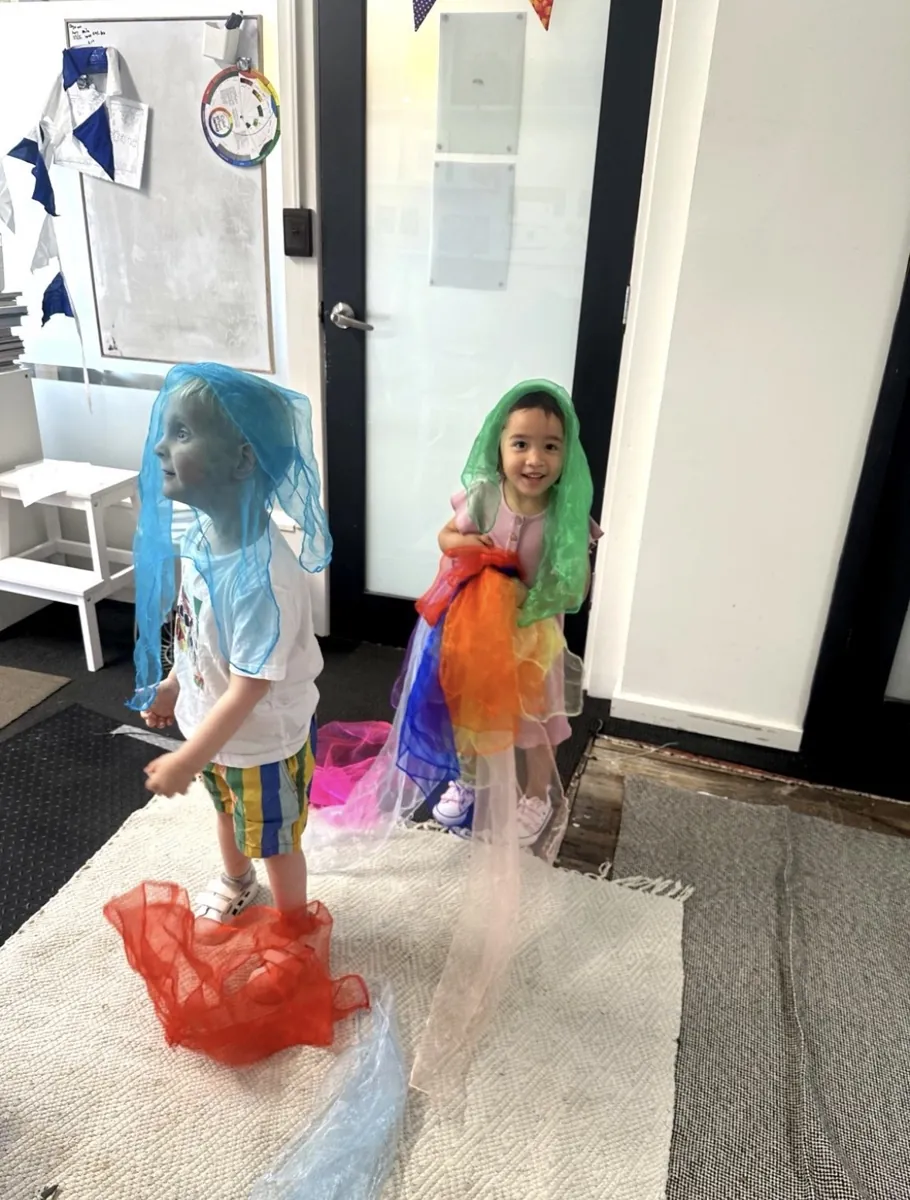 Young child playing with colourful streamers at a Tell & Show class